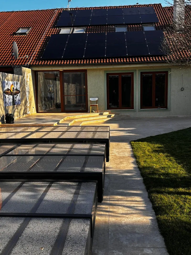 Fotovoltické panely okolo strešných okien na škridlovej streche domu